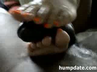 Asian babe gives an footjob to a black cock