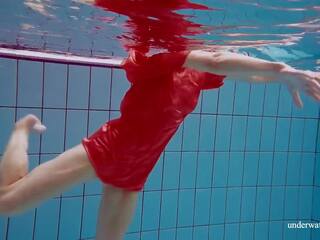 Червоний довго плаття і великий цицьки floating в the басейн